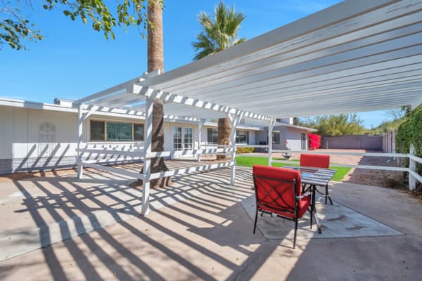 Outdoor patio with red chairs and a shaded area