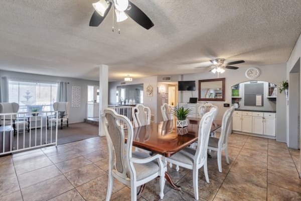 Dining table with elegant chairs and a view into the living area