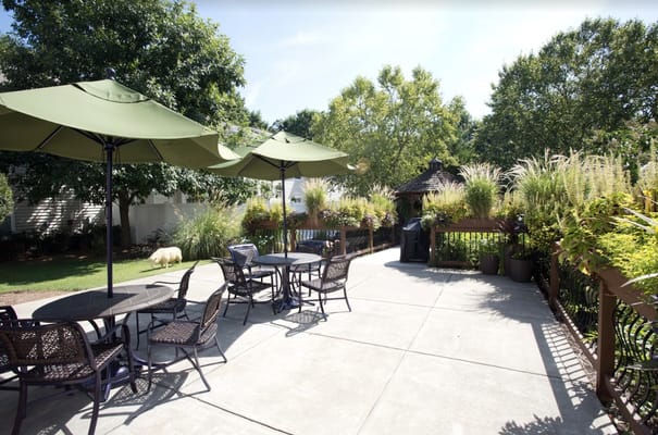 Outdoor seating area with green umbrellas and landscaping