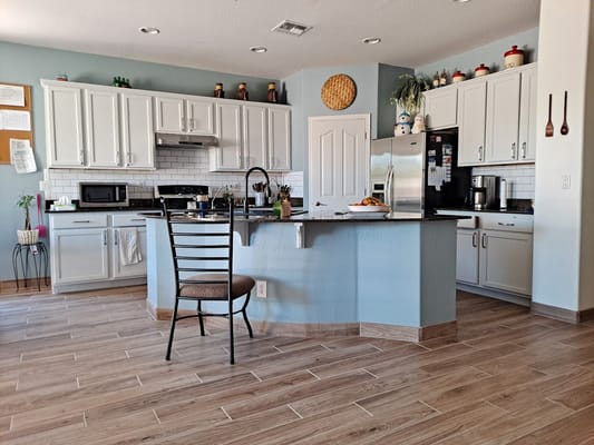 Spacious kitchen with white cabinets and a central island