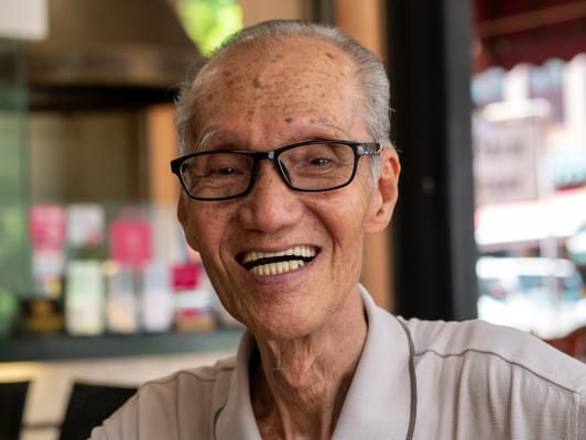 Elderly man smiling in a cozy setting