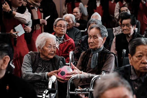 Senior residents interacting while holding a ball.