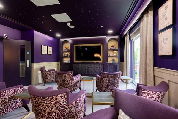 Lounge with purple chairs and a TV