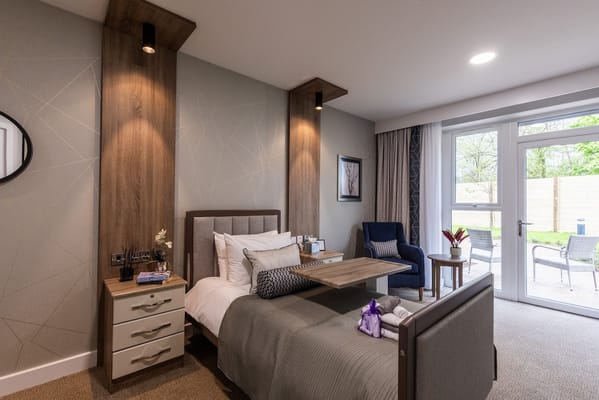 Cozy bedroom with a bed, chair, and patio door.