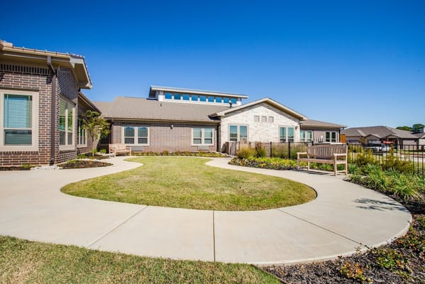 Landscape view of the garden and walkway at StoneCreek of North Richland Hills Senior Living.