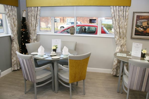 Cozy dining area with table settings and decorative curtains