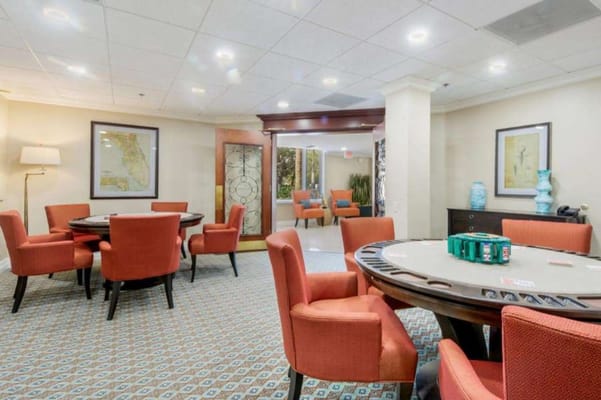 Cozy gaming room with poker table and orange chairs