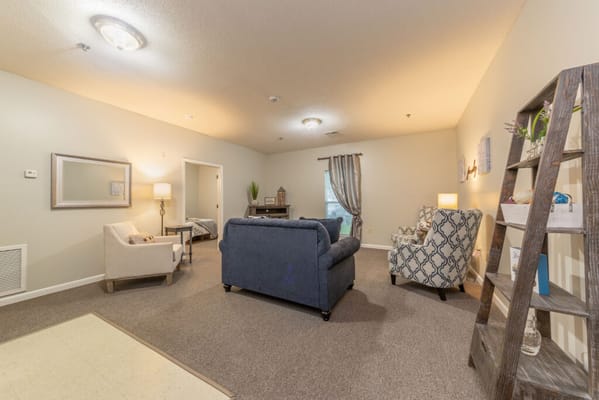 Cozy living room in senior living facility with two armchairs and a sofa