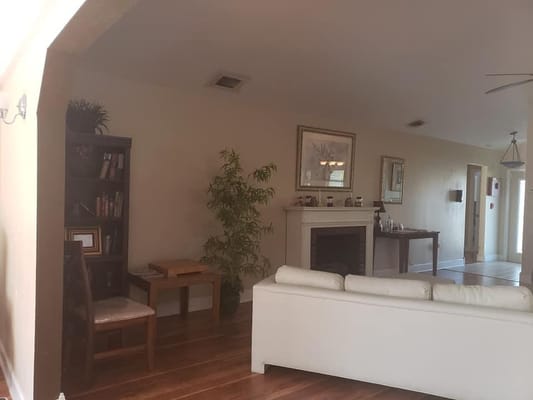 A cozy living room featuring a white couch, bookshelf, and a small table.
