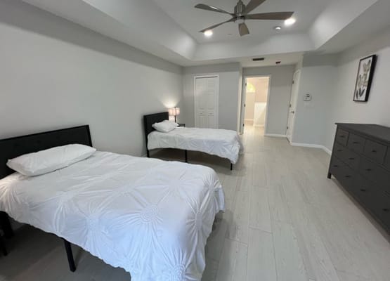 A well-lit shared resident room with two beds