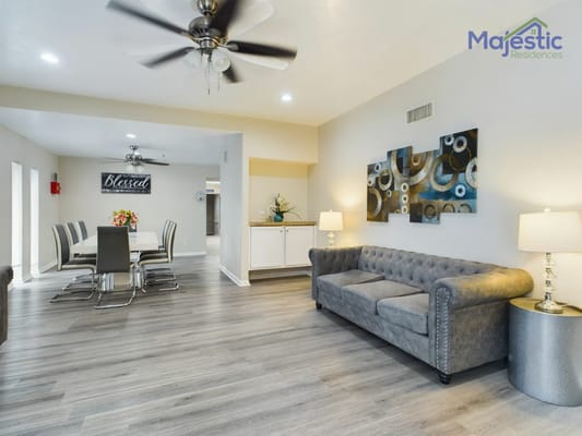 Comfortable living area with a gray sofa, dining table, and decorative art