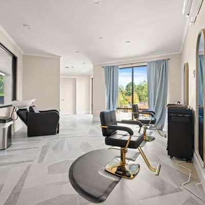 Bright and spacious hair salon with two styling chairs and large windows