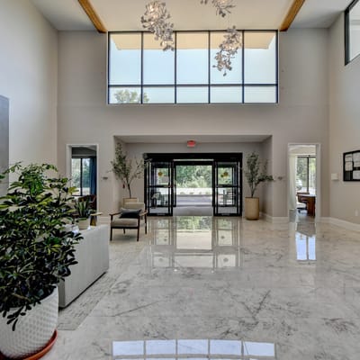 Bright lobby area with large windows and marble flooring