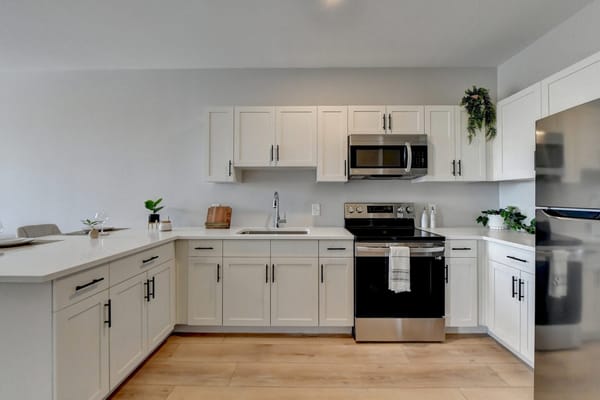 Modern kitchen with white cabinets and stainless steel appliances