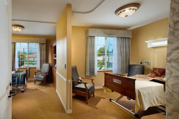 A well-furnished resident room with natural light