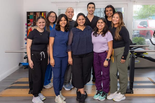 Staff members posing in a physical therapy room