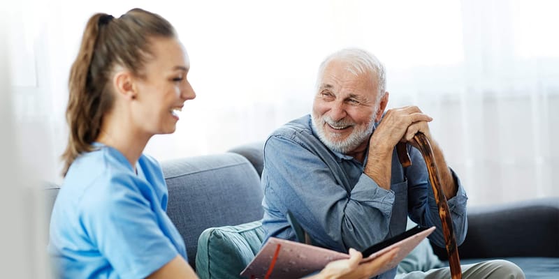 A caregiver smiling with a resident in a common area