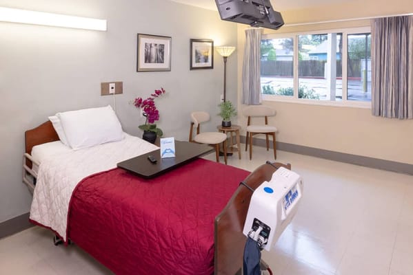 A private resident room with a bed and seating area