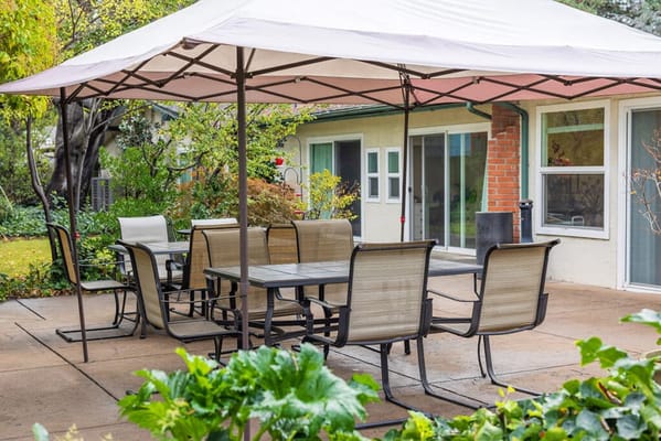 Outdoor seating area under a tent with tables and chairs