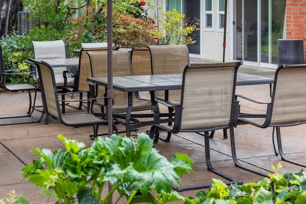 Outdoor seating area with tables and chairs in a garden