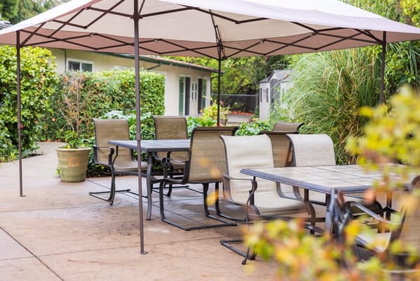 Outdoor seating area with tables and chairs under a canopy