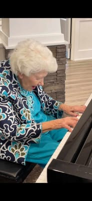 Resident playing piano in a vibrant activity space