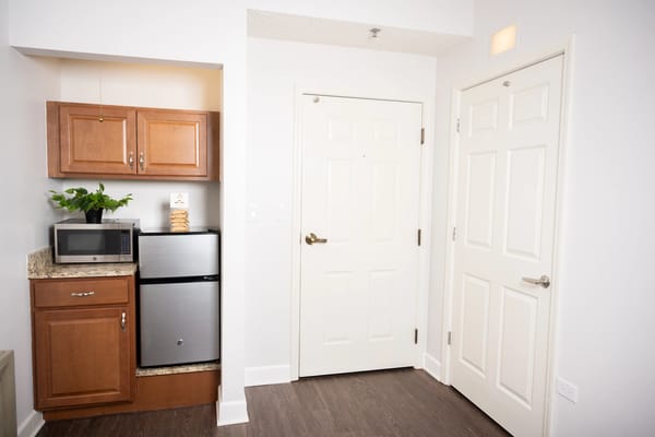 Interior of a resident's kitchen area with microwave and fridge