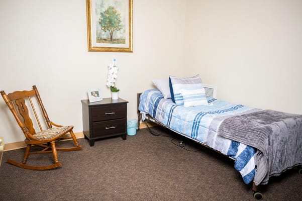 A cozy resident room with a bed and chair