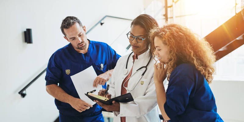 Healthcare staff discussing patient care in a facility corridor