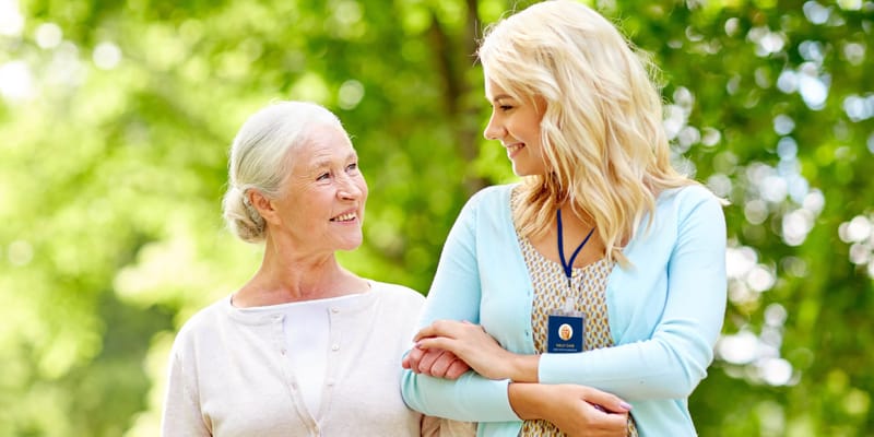 Caregiver and resident enjoying a walk in the gardens