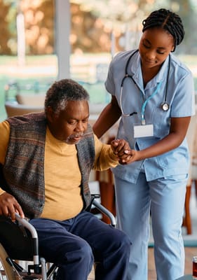 Nurse assisting a resident in a wheelchair indoors