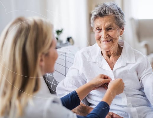 Caregiver assisting an elderly woman in a bright interior setting