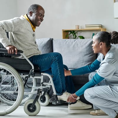 A caregiver assisting a wheelchair-bound resident