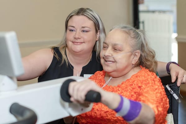 Staff assisting a resident with rehabilitation exercise