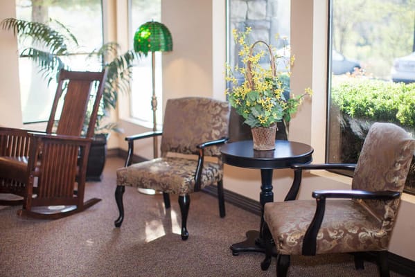 Well-furnished common area with rockers and plants