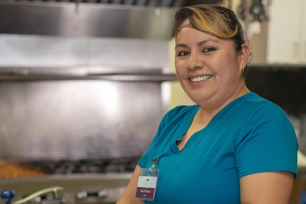 Staff member smiling in the kitchen area