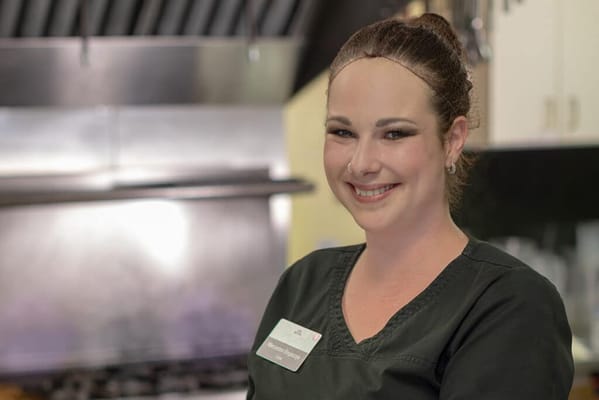 A staff member smiling in a kitchen area