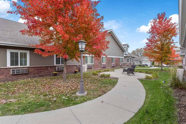 Outdoor pathway lined with colorful trees at the facility