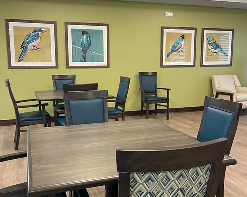 Bright common area with tables and bird art