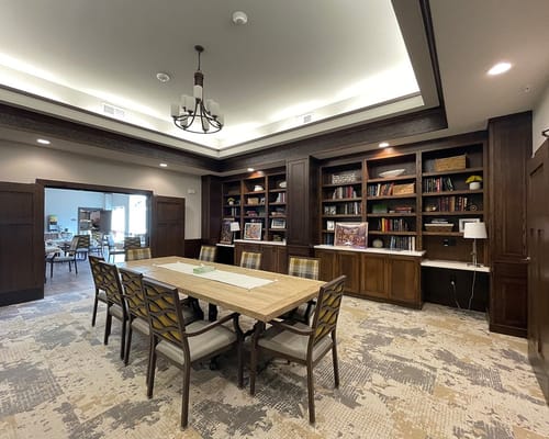Bright common area with bookshelves and a dining table