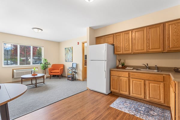 A cozy resident room with kitchenette and seating area
