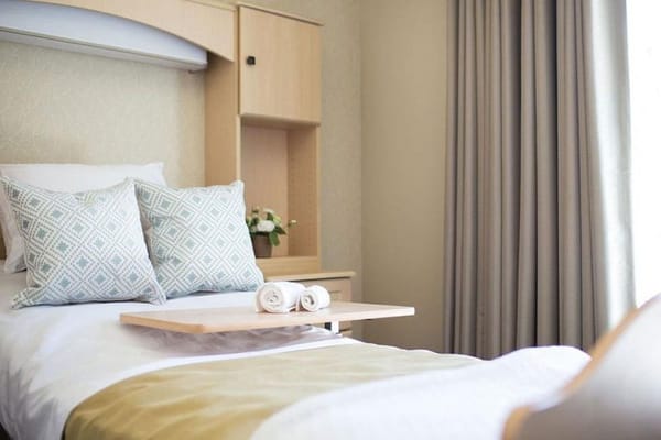 A well-decorated private resident room with a bed and table