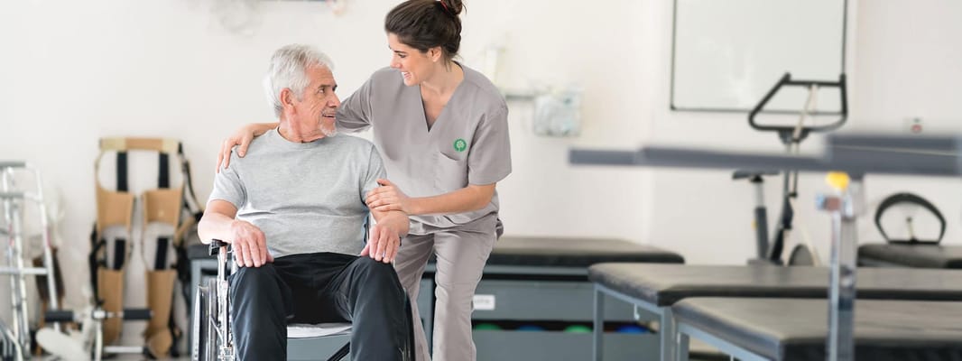 A caregiver assisting a resident in a therapy room