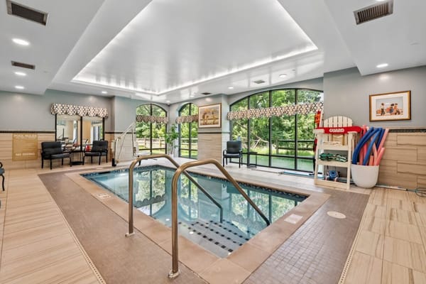 Indoor swimming pool area with lounge chairs and safety equipment
