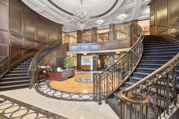Elegant lobby with curved staircase and chandelier