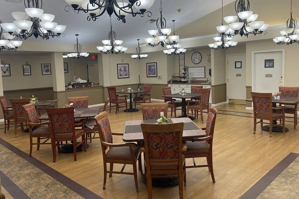 Dining room with tables and chairs set for residents