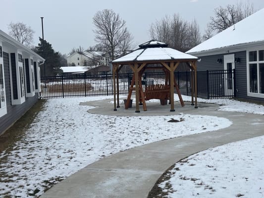 Snow-covered outdoor space with a gazebo and pathway
