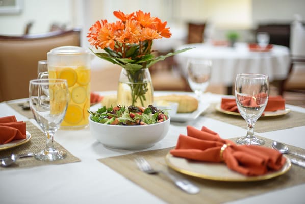 Beautifully set dining table with meal and flowers