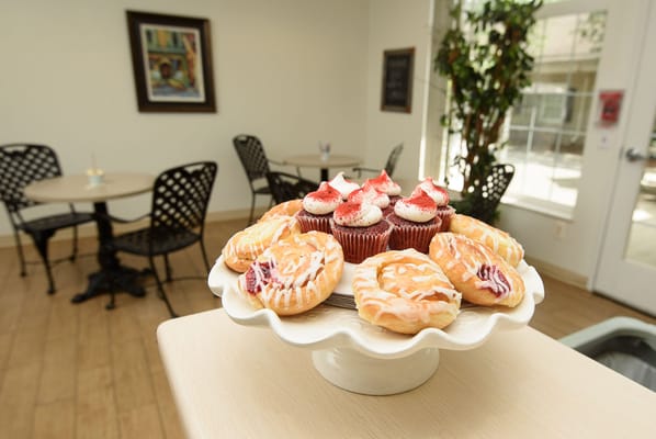 A dessert platter with pastries and cupcakes in a dining area