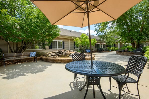 Outdoor seating area with trees and landscaping